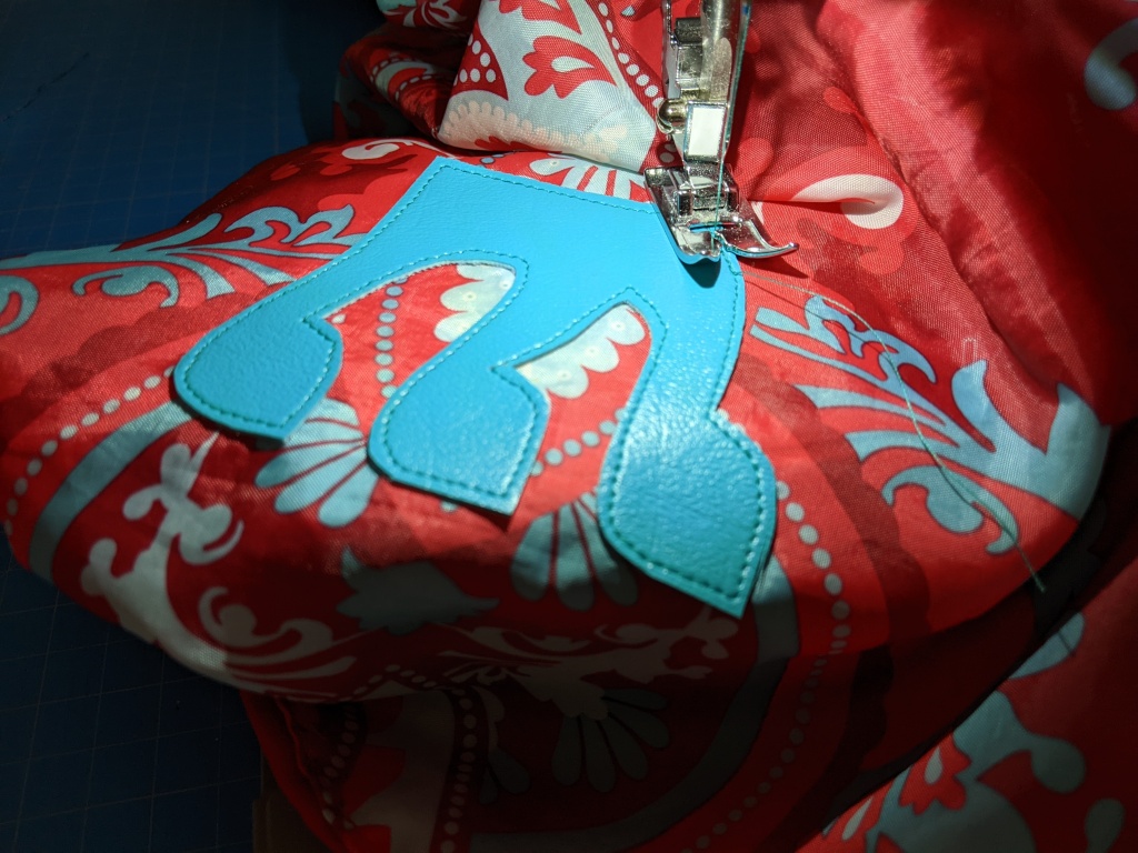 Sewing Hebrew monogram applique onto tote bag